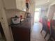 Galley kitchen with granite countertops and stainless steel sink; leading to dining area at 11625 Constance Dr, Port Richey, FL 34668