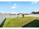 Backyard with a lake view, white fence, and well maintained lawn at 11760 Winterset Cove Dr, Riverview, FL 33579
