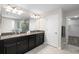 Modern bathroom featuring dual sinks, granite countertops, and a separate room with a walk-in closet at 11760 Winterset Cove Dr, Riverview, FL 33579