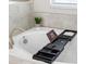 Close-up of a luxurious bathtub with a black book and a convenient tray on top at 11760 Winterset Cove Dr, Riverview, FL 33579