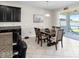 Open-concept dining area featuring dark cabinets, granite countertops, a wood table, and a sliding glass door leading to a patio at 11760 Winterset Cove Dr, Riverview, FL 33579