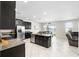 Open-concept kitchen with dark cabinetry, stainless appliances, granite counters, and a center island flowing into the living space at 11760 Winterset Cove Dr, Riverview, FL 33579