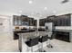 Modern kitchen featuring dark cabinetry, stainless steel appliances, granite countertops and an island with barstool seating at 11760 Winterset Cove Dr, Riverview, FL 33579