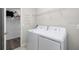 Laundry room with white washer and dryer, wire rack, and an open door at 11760 Winterset Cove Dr, Riverview, FL 33579