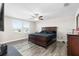 Main bedroom featuring a large bed, dark furniture, natural light from two windows and wood-look floors at 11760 Winterset Cove Dr, Riverview, FL 33579