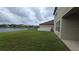 A serene backyard view with a lake and grassy area, partially fenced at 11839 Cross Vine Dr, Riverview, FL 33579