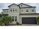 Two-story home featuring a dark garage door, neutral stucco exterior and meticulously maintained landscaping at 11839 Cross Vine Dr, Riverview, FL 33579