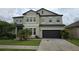 Two-story home featuring a dark garage door, neutral stucco exterior and meticulously maintained landscaping at 11839 Cross Vine Dr, Riverview, FL 33579