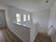 Bright hallway with wood flooring, a staircase, windows, and white walls at 11839 Cross Vine Dr, Riverview, FL 33579