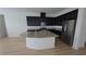 Close-up of kitchen island with granite countertop, dark cabinets, and stainless steel appliances in a modern kitchen at 11839 Cross Vine Dr, Riverview, FL 33579