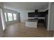 Bright open-concept kitchen featuring dark cabinets, stainless steel appliances, and a large island with granite countertops at 11839 Cross Vine Dr, Riverview, FL 33579