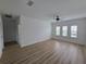 Bright living room with wood floors, ceiling fan, multiple windows, and neutral paint at 11839 Cross Vine Dr, Riverview, FL 33579