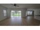 Spacious living room with light-colored wood flooring, ample windows, and views of backyard and pond at 11839 Cross Vine Dr, Riverview, FL 33579