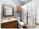 Bathroom features wood vanity, framed mirror, and shower with decorative curtain at 12008 Fern Blossom Dr, Gibsonton, FL 33534