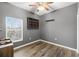 Bedroom with wood-look floors, window with blinds, and storage shelves at 12008 Fern Blossom Dr, Gibsonton, FL 33534