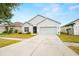 Charming single-story home with a well-maintained lawn and a two-car garage at 12008 Fern Blossom Dr, Gibsonton, FL 33534