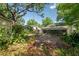 Spacious backyard featuring a brick patio with a fire pit, surrounded by mature trees and landscaping at 1211 E Park Cir, Tampa, FL 33604