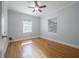 A well-lit bedroom with hardwood floors, two windows and a ceiling fan at 1211 E Park Cir, Tampa, FL 33604