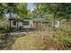 Quaint single-story home with inviting front porch and a lush front yard with mature trees at 1211 E Park Cir, Tampa, FL 33604