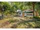 Charming home with mature landscaping, a cozy front porch and a cheerful yellow door at 1211 E Park Cir, Tampa, FL 33604