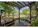 Inviting outdoor porch featuring comfortable seating, a beautiful pergola, and picturesque views of the surrounding neighborhood at 1211 E Park Cir, Tampa, FL 33604