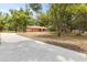 Brick home with an attached garage and concrete driveway surrounded by large trees at 12514 Avery Rd, Thonotosassa, FL 33592