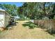Large backyard with a patio area, mature trees, and a wood fence at 135 Rodney Ct, Palm Harbor, FL 34684