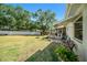 Expansive backyard featuring a patio, mature trees, and a white fence at 135 Rodney Ct, Palm Harbor, FL 34684