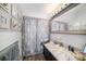 Bright bathroom with updated vanity, decorative mirror, and tiled shower at 135 Rodney Ct, Palm Harbor, FL 34684