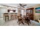 Open dining area adjacent to the kitchen and living room, featuring tile floors and a ceiling fan at 135 Rodney Ct, Palm Harbor, FL 34684
