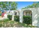 Beautiful home featuring arched entryways framed by mature landscaping at 135 Rodney Ct, Palm Harbor, FL 34684