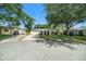 Wide angle view of a quaint home with a spacious driveway and well-manicured front lawn at 135 Rodney Ct, Palm Harbor, FL 34684