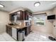 Well-lit kitchen with tile flooring, dark wood cabinets, and modern appliances at 135 Rodney Ct, Palm Harbor, FL 34684