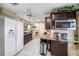 Open kitchen with white appliances, granite countertops, and tile flooring at 135 Rodney Ct, Palm Harbor, FL 34684