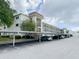 Exterior view of condo building featuring parking, landscaping, and architectural details at 1375 Doolittle Ln # 101, Dunedin, FL 34698