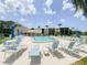 Community pool with ample lounge seating, tables with umbrellas, and a sunny seating area at 1375 Doolittle Ln # 101, Dunedin, FL 34698