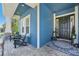 Charming front porch with decorative columns, brick pavers, and black door with wreath, enhancing curb appeal at 14319 Rolling Dune Rd, Lithia, FL 33547
