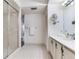 Bathroom features white tile flooring, a vanity, mirror, and glass-enclosed shower at 14820 Rue De Bayonne # 208, Clearwater, FL 33762