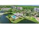 Aerial view of community pool and clubhouse surrounded by lush landscaping and beautiful ponds at 14820 Rue De Bayonne # 208, Clearwater, FL 33762