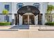 Elegant entrance with a black awning, complemented by well-maintained landscaping and stylish architectural details at 14820 Rue De Bayonne # 208, Clearwater, FL 33762
