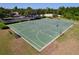 Community basketball court in green with benches, surrounded by grass and trees at 1723 Whitewillow Dr, Wesley Chapel, FL 33543