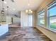 Well-lit dining area with tile flooring and a view of the backyard through large windows at 1723 Whitewillow Dr, Wesley Chapel, FL 33543