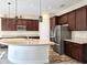 Modern kitchen boasts stainless steel appliances, dark wood cabinets, and granite counters for a sleek look at 1723 Whitewillow Dr, Wesley Chapel, FL 33543