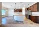Spacious open-concept kitchen with dark wood cabinets, a large island, stainless steel appliances, and sleek tile flooring at 1723 Whitewillow Dr, Wesley Chapel, FL 33543