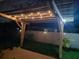 Outdoor patio with a wooden pergola decorated with string lights at night at 1723 Whitewillow Dr, Wesley Chapel, FL 33543