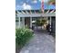 Inviting pool entrance with American flag, stone pavers, wrought iron gate, and lush landscaping at 1799 N Highland Ave # 170, Clearwater, FL 33755