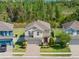 Aerial view of a two-story home with a manicured lawn and a brick-paved driveway at 19487 Roseate Dr, Lutz, FL 33558