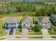 Aerial view of a neighborhood featuring well-maintained homes, green spaces, and a nearby lake at 19487 Roseate Dr, Lutz, FL 33558