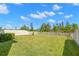 Expansive backyard with lush green grass, a white fence, and a clear blue sky at 19487 Roseate Dr, Lutz, FL 33558