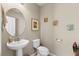 Stylish powder room with a pedestal sink, decorative art, and neutral tones, creating a serene and inviting space at 19487 Roseate Dr, Lutz, FL 33558